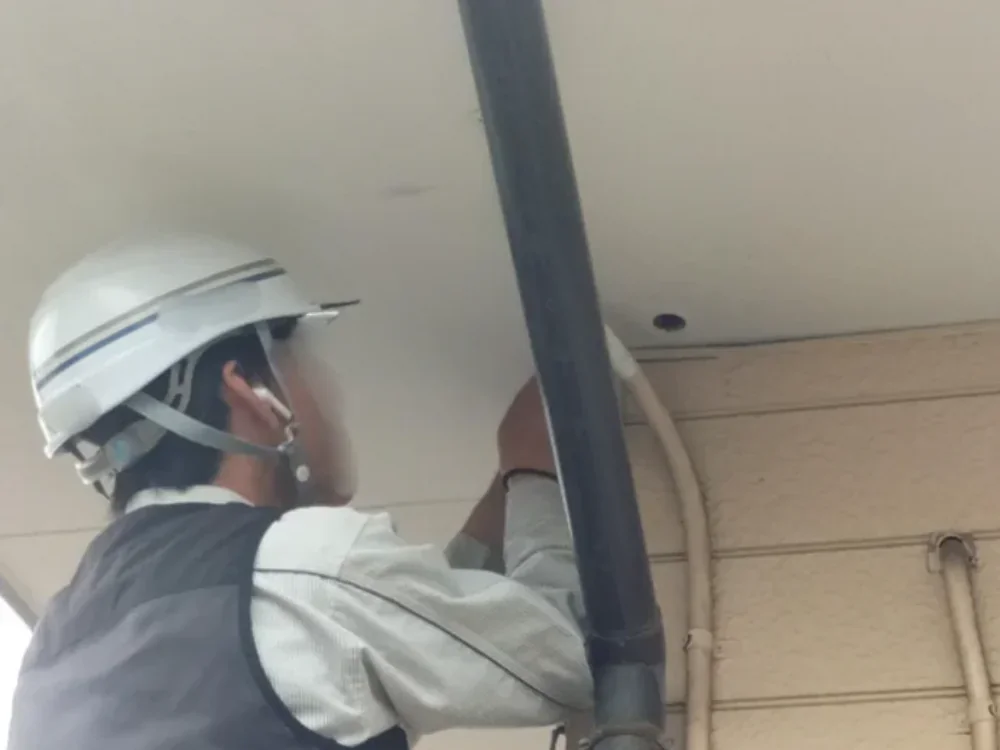 壁に穴あけをして光ファイバーケーブルを家の中に引き込んでいる様子の写真